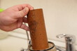 Old brown water filter in the hand. Plumbing water filter cartridge replace maintenance service.