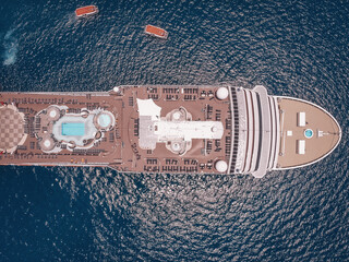 Large luxury cruise ship in the blue waters of the Andaman sea, 2 boats around; aerial view.