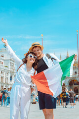 Wall Mural - smiling couple holding italian flag venice central square san marco