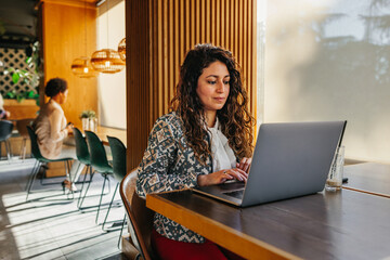 Woman at coffee shop using laptop