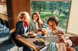 © bernardbodo - Three businesswomen taking selfie at restaurant