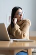 © opolja - Smiling woman with laptop in home office.