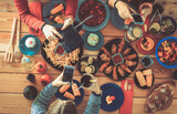 Fototapeta Uliczki - Top view of group of people having dinner together while sitting at wooden table