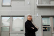 © Johnér - Senior woman standing in front of building