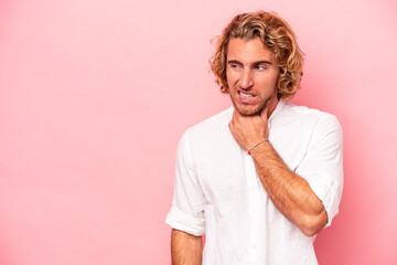 Wall Mural - Young caucasian man isolated on pink background touching back of head, thinking and making a choice.