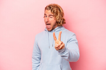 Wall Mural - Young caucasian man isolated on pink background showing number two with fingers.