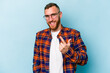 © Asier - Young caucasian man isolated on blue background pointing with finger at you as if inviting come closer.