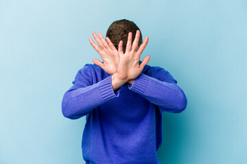 Young caucasian man isolated on blue background keeping two arms crossed, denial concept.