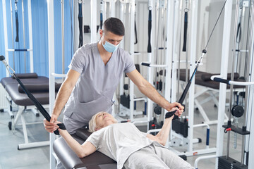 Wall Mural - Lying woman training arms with cable machine