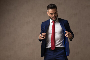 Poster - fashion businessman arranging his nice navy suit