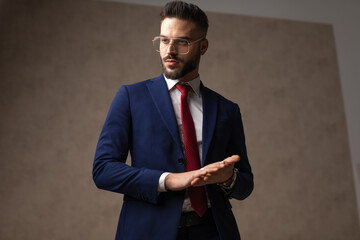 handsome businessman rubbing his palms, looking away