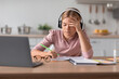 © Prostock-studio - Tired busy european youngsters girl blonde in headphones studying at home at table with laptop