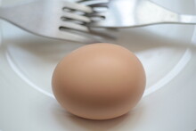 A Whole Hard-boiled Egg With The Shell On A Plate
