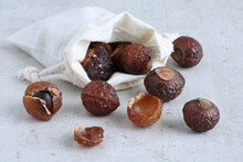 Soapberries Or Soap Nuts  In A Cotton Bag On A Gray Concret Background Close Up. Natural Detergent In Sustainable House.