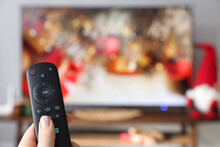 Woman With Remote Control Watching TV At Home, Closeup. Space For Text