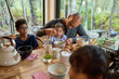 © Trevor Adeline/Caia Image - Father feeding toddler daughter at cabin dining table
