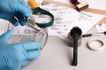 Forensic fingerprint analysis, criminalist collects latent fingerprints using fingerprint powder on evidence