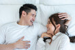 Portrait of Asian new marriage couple lying on bed and look each other. 