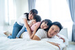 © Kawee - Portrait of Asian happy family smile and look at camera on bed at home.