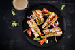 Club sandwich with chicken breast, cheese, tomato, cucumber and herbs.  Top view, overhead