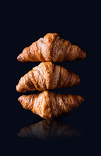 Pile Of Three Gold Croissants On The Black Background Close Up - Poster Layout