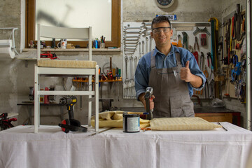 Sticker - handyman at work with the restoration of old chairs in his garage. Craft work