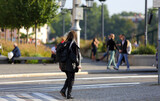 Fototapeta  - Piękna kobieta, dziewczyna z plecakiem spaceruje po chodniku, deptaku we Wrocławiu.	
