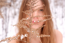 Blurred Face Of A Girl Behind A Branch. 