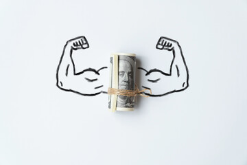 the concept of a strong world currency. muscle hands with a bunch of us dollars money.