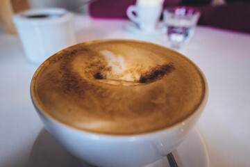 Wall Mural - A closeup of a coffee with foam in a cafe on a blurred background