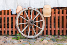 Old Wooden Wheel Near Wooden Fence - Lithuania