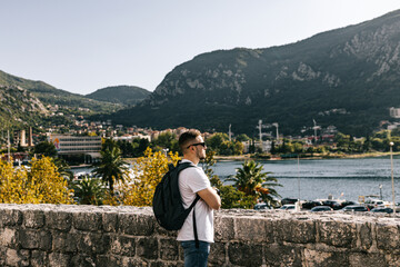 Man stands on Kotor old wall Fortification in Montenegro. Unesco world heritage. Europe travel site. Vacation concept.  Tourism in adriatic sea. Serbian history of balkans, fort and port buildings..