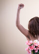 © kharoll Mendoza - Strong woman holding a flowers in her hand, show her natural body female hairy armpit, fashion trend concept power feminism, unshaven underarms on yellow background.