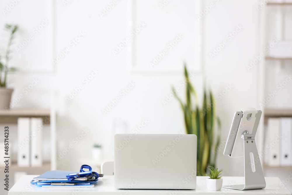 Modern doctor's workplace with laptop and tablet computer in medical office