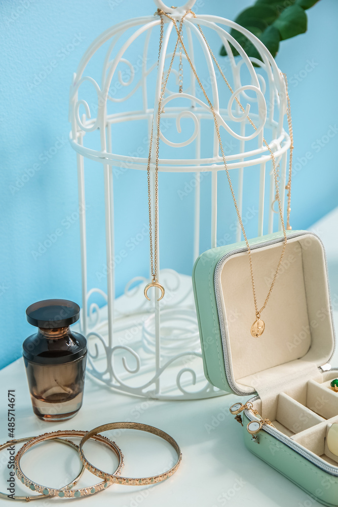 Perfume bottle, opened organizer and stylish jewelry on white table