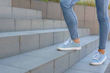 Wall Mural - woman walking upstairs outdoors, closeup