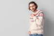 © Pixel-Shot - Handsome young man in knitted sweater on grey background