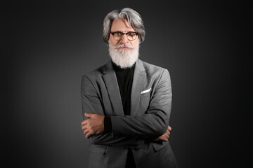 Poster - Portrait of handsome mature bearded businessman on dark background