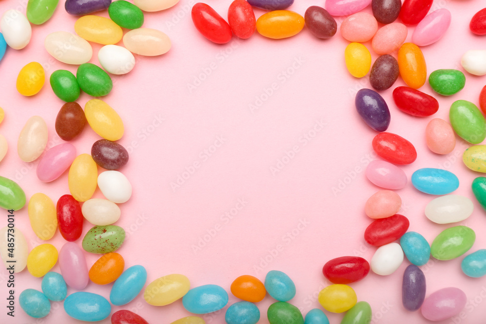 Frame made of multicolored jelly beans on color background