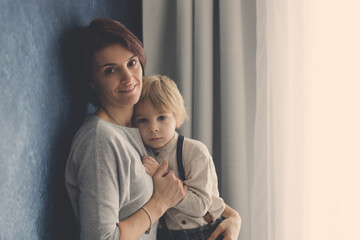 Poster - Portrait of mother and child, hugging on a back lit white background