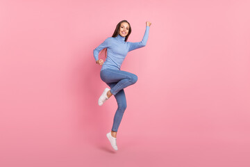 Wall Mural - Photo of crazy triumphant lady jump celebrate victory raise fists wear blue turtleneck isolated pink color background