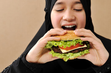 Wall Mural - Arabian girl eating burger , high quality photos