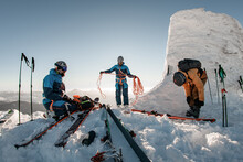 Beautiful view of group of skiers in ski suits and helmets with climbing mountaineering equipment and skis around