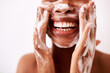 © Chanelle Malambo/peopleimages.com - Keeping my skin clean is what keeps it looking good. Studio shot of an unrecognizable woman washing her face against a white background.