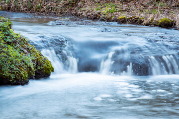 Canvas Print - Waterfall on river with bright green moss on the bank. Wild nature, clean water floating through the waterfall