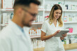 © Zamrznuti tonovi - Happy young male and female colleagues pharmacist working in a pharmacy