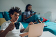 © Zamrznuti tonovi - African american couple relaxing on couch with laptop and coffee at home