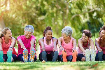 Poster - Limbering up before exercise. Shot of a group of people warming up outdoors.