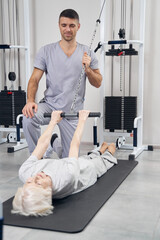 Wall Mural - Female pensioner having a rehabilitation exercise for her arms