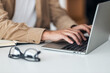 © Jelena - Close up of a mans hands typing on a laptop keyboard.